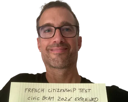Yann smiling behind a yellow notepad sheet that reads "French citizenship test: civic exam 2026 explained"