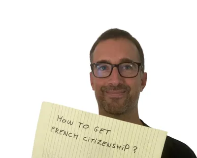 Yann smiling behind a yellow notepad sheet that reads "How to get French citizenship?"