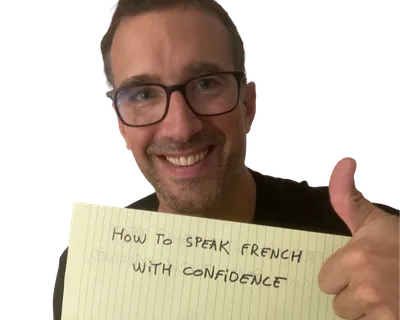 Yann smiling with a thumbs up next to a yellow notepad sheet that reads "How to speak French with confidence"