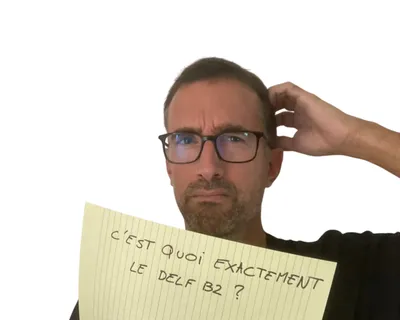 Yann scratching his head over a yellow notepad sheet that reads "C'est quoi exactement le DELF B2 ?"