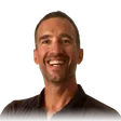 Yann, smiling at the camera, in a dark polo shirt