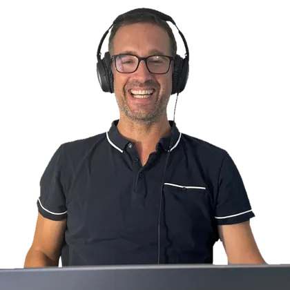 Yann teaching a French session over video call, headphones on, laughing at something a student said